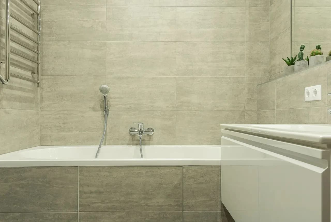 Finished bathroom with wall tiles, bathtub and vanity