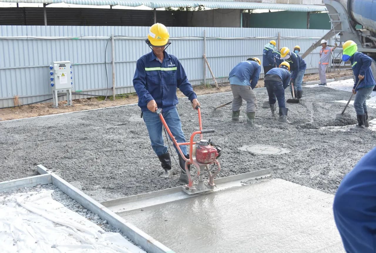 Construction workers levelling freshly poured concrete